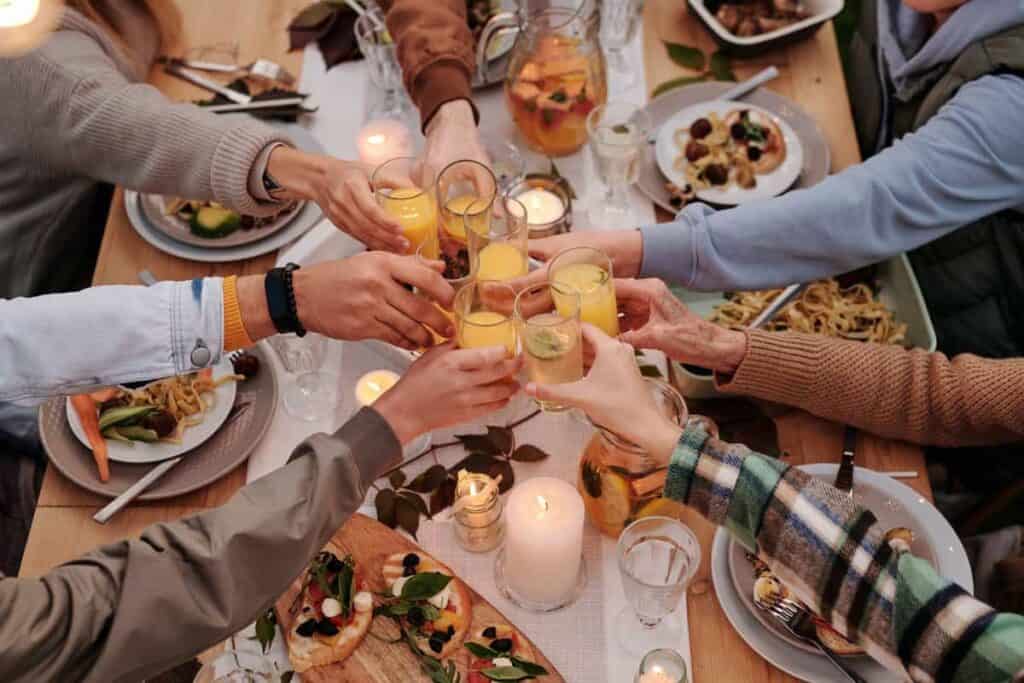 people are drinking and eating together at the table