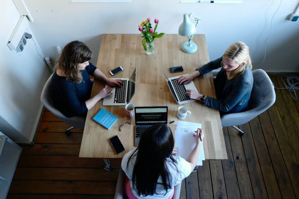 three women working on a laptop in a room