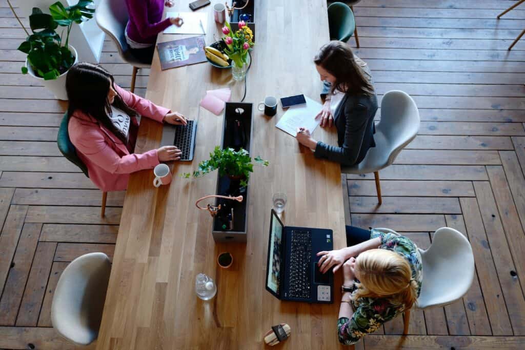 three individuals working on a table together