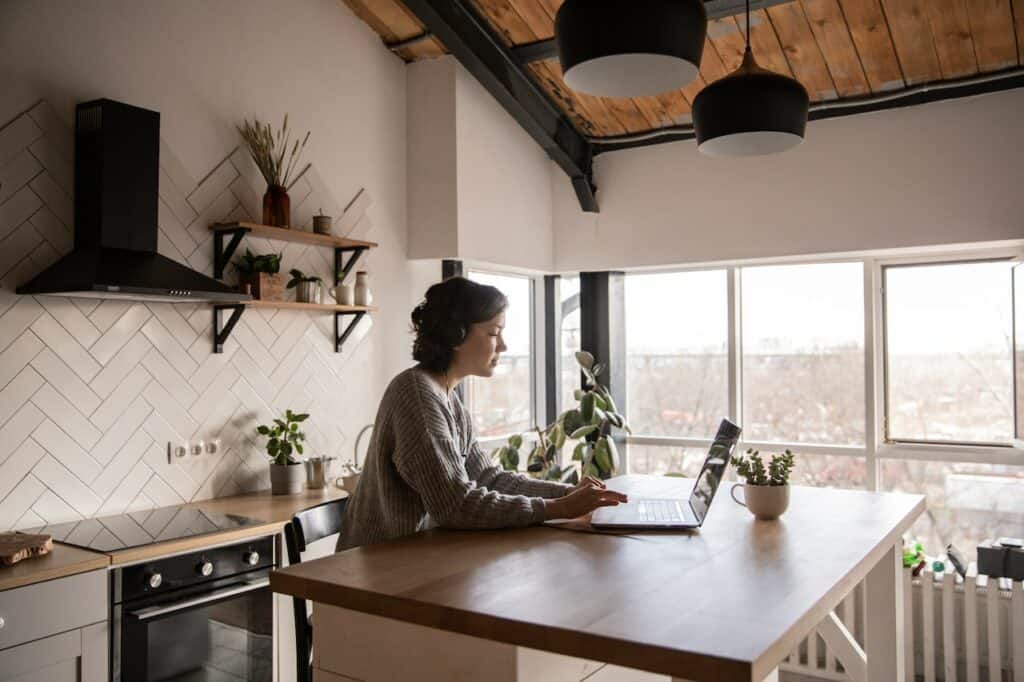 A girl working on the laptop in the kitchen