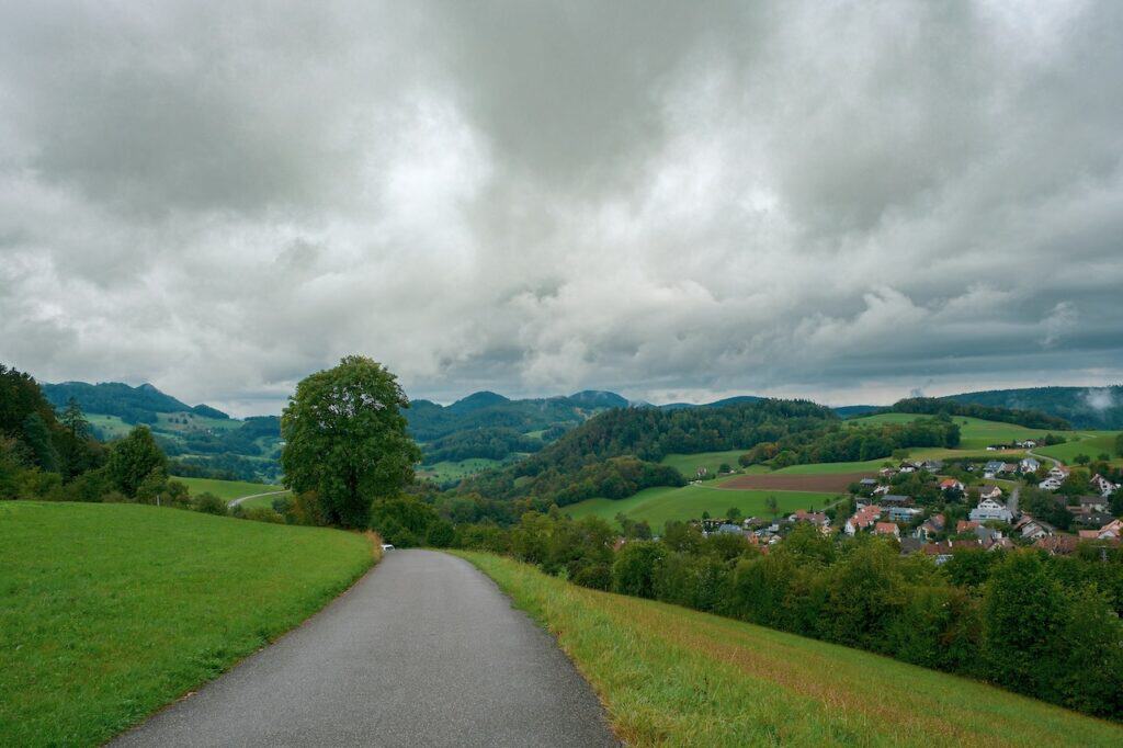 Road with grass fields on the side rural landscape