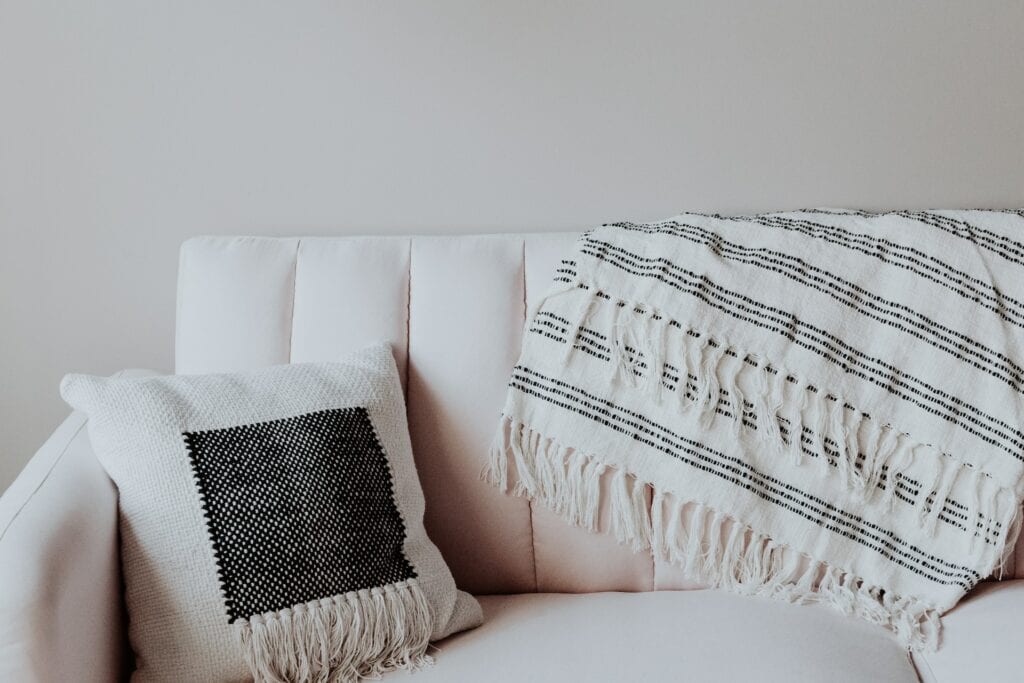 white pillow with black design on a white couch