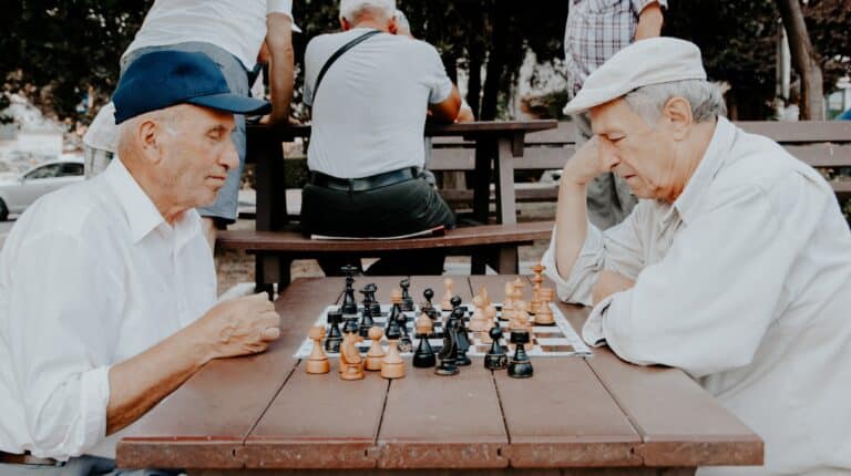 Two elderly people playing chess together.