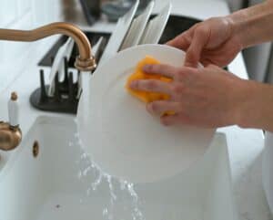 Washing dishes in the sink of the kitchen.