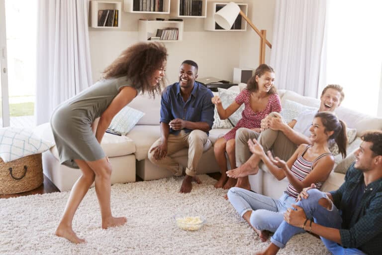 Group Of Friends At Home Having Fun Playing Charades Together