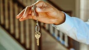 Close-up of a hand holding a house key, symbolizing a new home or apartment rental.