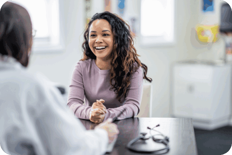 Smiling woman sitting across from a doctor in a consultation room