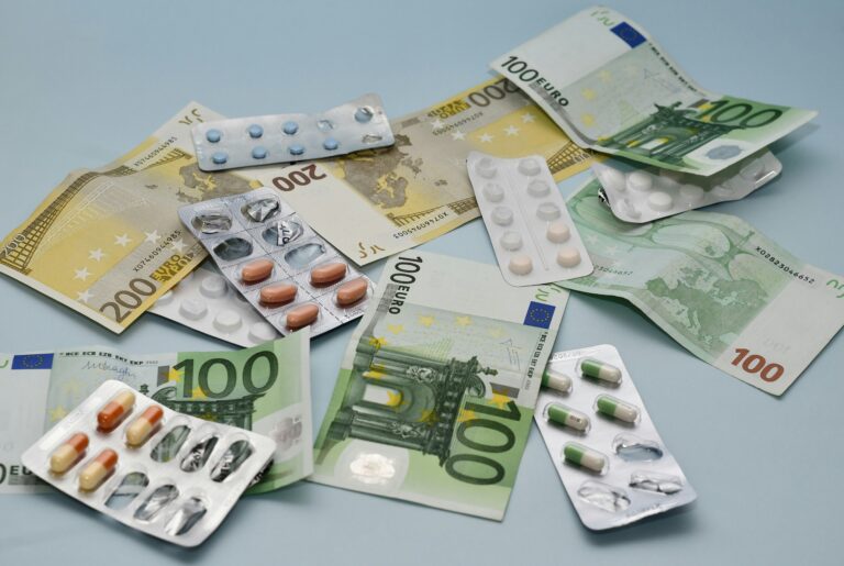 Medications and euro banknotes surrounding a Belastingdienst envelope