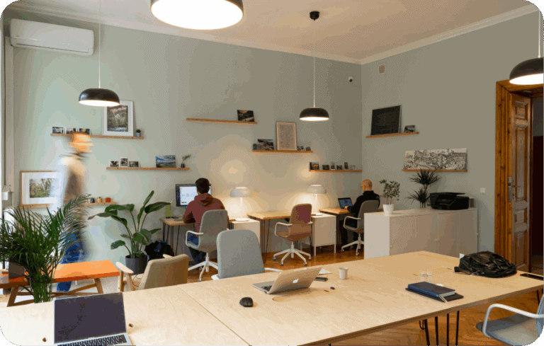 Modern co-working office with employees working at desks and laptops