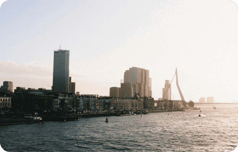 Rotterdam city skyline with Erasmus Bridge and river in early morning light"