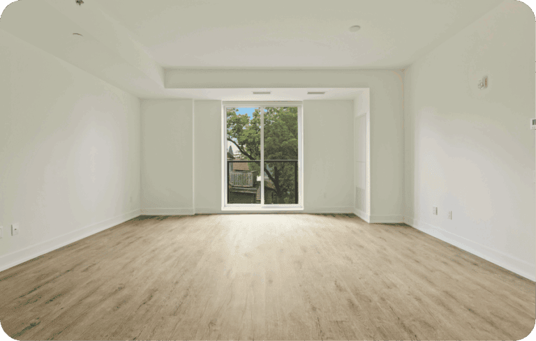 Empty, unfurnished modern apartment interior with large window and wood floors, highlighting long-term rental challenges