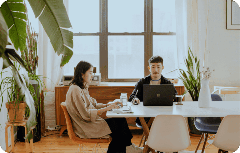 People working in a modern coworking space with plants and natural light