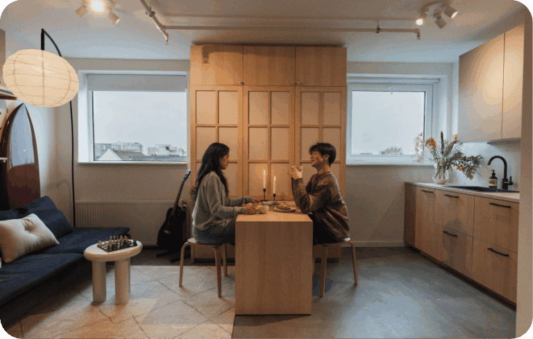 Couple dining in a studio apartment with integrated storage